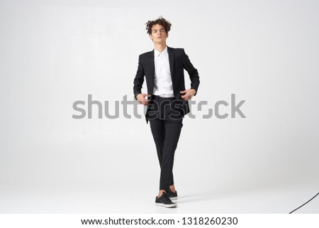 Cute man in a suit in full growth office worker gray background