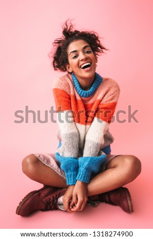 Image of a happy beautiful young african woman posing isolated over pink wall background.