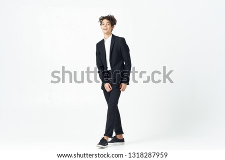 Cute elegant man in a black suit office worker on a light background