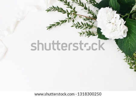 Festive wedding, birthday composition with eucalyptus parvifolia branches, hydrangea flowers and silk ribbon. White table background. Rustic styled stock photo. Empty space, flat lay, top view