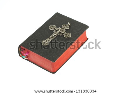 silver cross on old holy bible, isolated on white background