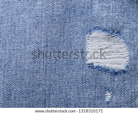 closeup picture of a part of the jeans that is a bit torn


