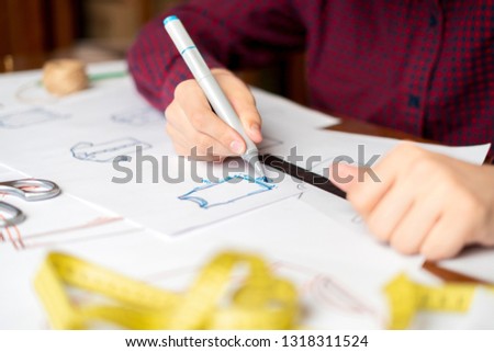 designer drawing new fashion wear on paper