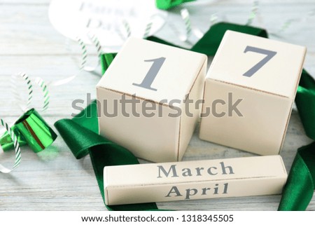 Calendar with date 17 MARCH and party decor on wooden table. St. Patrick's Day celebration