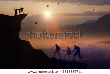 The team of teen climbers are helping each other to climb the hill, climbers that hold their hands on the top of the mountain and have a balloon floating in the sky in the beautiful morning, teamwork  Royalty-Free Stock Photo #1318364711