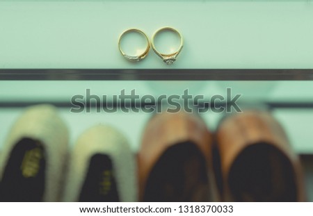 Wedding couple diamond rings and couple shoes. focus at rings.