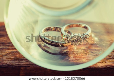 The diamond couple wedding rings is placed in glass.