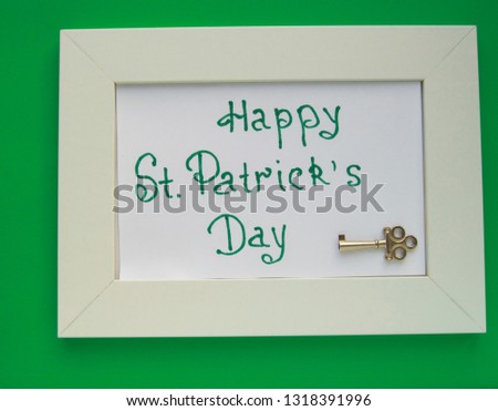 St. Patrick's day greeting card with white frame on green background, key to wealth and treasures