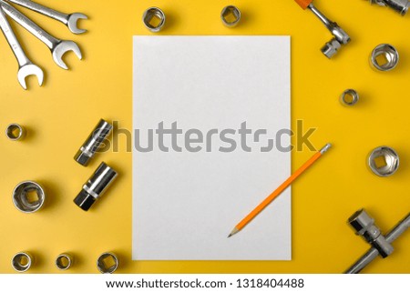 Top view of different wrenches and one monkey wrench on the yellow background. Flat lay. Copy space for text