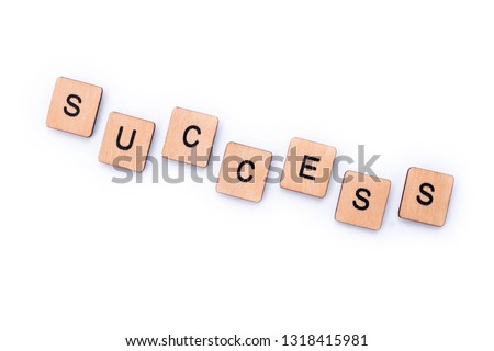 The word SUCCESS, spelt with wooden letter tiles over a white background.