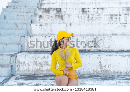 Portrait of beautiful asian woman in yellow cloths,Hipsters girl wear yellow hat on stair for take a picture,Thailand people in yellow tone style