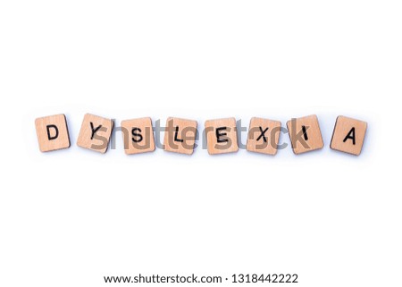 The word DYSLEXIA, spelt with wooden letter tiles over a white background.
