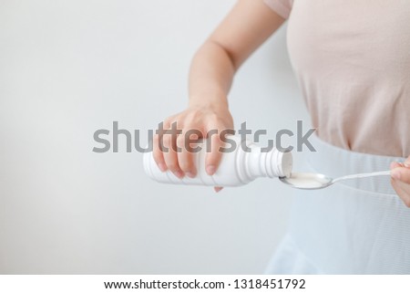 Women pouring drugs or antacids in their hands because of the food from their hands to the bottle. Concepts of health care, people and medicine