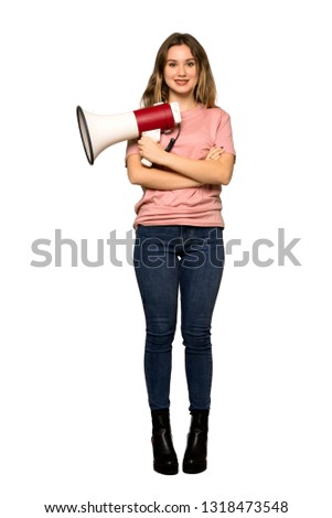 A full-length shot of a Teenager girl with pink sweater holding a megaphone on isolated white background