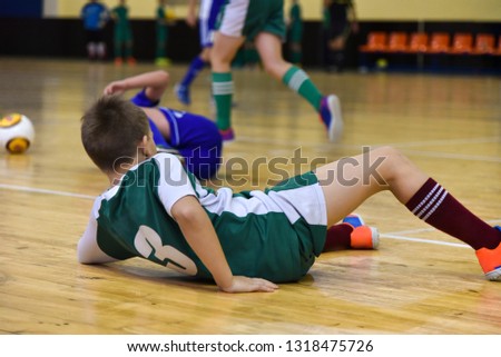 teenager rolled over, fell and was injured while playing mini football in the gym Royalty-Free Stock Photo #1318475726