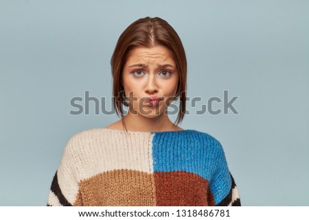 Portrait of emotionally wounded woman with a sad expression on face, crooked lower lip with a disgruntled look. The girl received bad words about her work, feels disappointed.