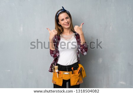 Craftsmen or electrician woman giving a thumbs up gesture and smiling