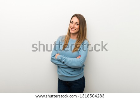 Blonde woman on isolated white background keeping the arms crossed in frontal position
