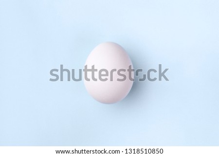 white egg on pastel blue background, concept Happy Easter