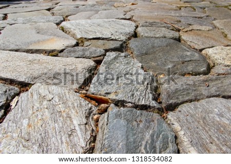 An old pavement cobbled with natural rocks. Photo in perspective 