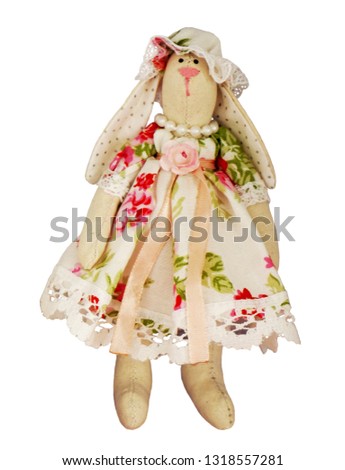 Isolated textile soft toy hare girl rabbit, easter bunny in a dress and hat
