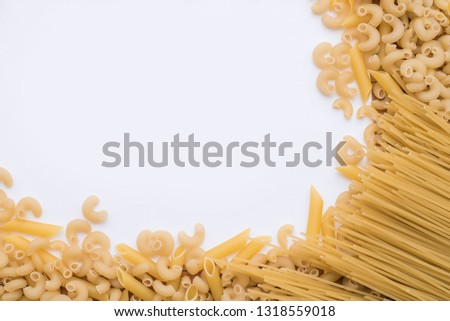 Background of scattered uncooked Italian maccheroni pasta shells. Free place for text