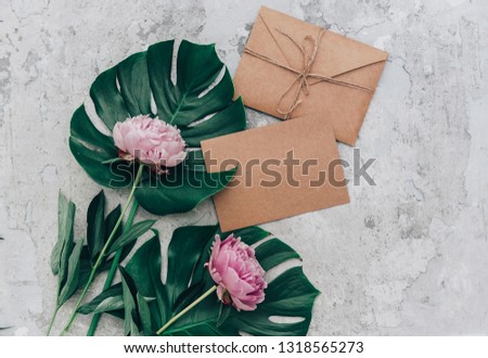 Craft Envelope and pink pale peony on tray background. Top view, flat lay , Mothers Day, Woman day concept. 