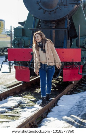 Young woman is walking in the railroad tracks.