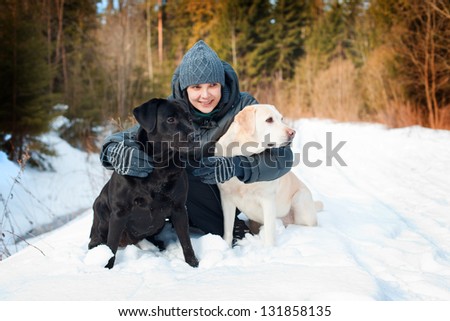 The girl with Labradors on walk in the winter wood