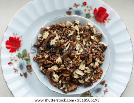 Walnut in plate on wooden table, above walnut image