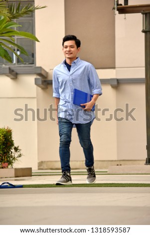 Smart Diverse Male Student With Notebooks Walking On Campus