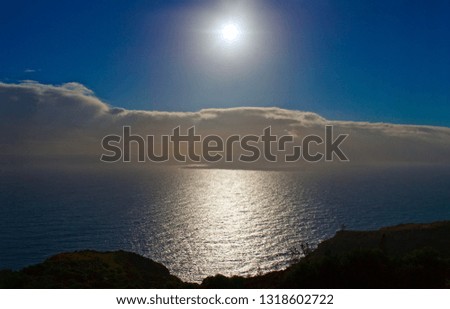 Sunshine reflecting through clouds onto the ocean.