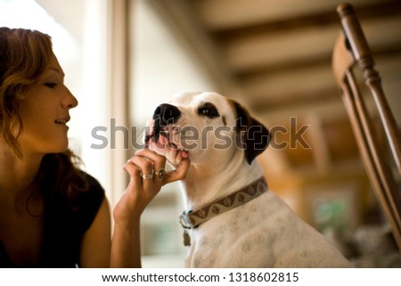 Young woman petting her dog.