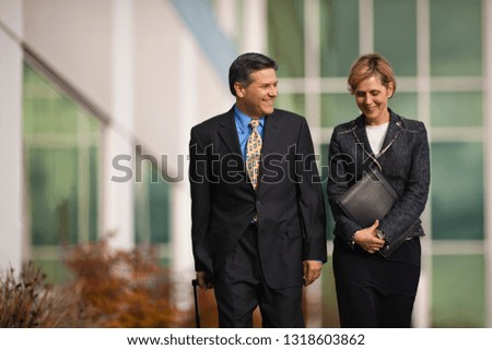 Two colleagues discuss business as they walk.