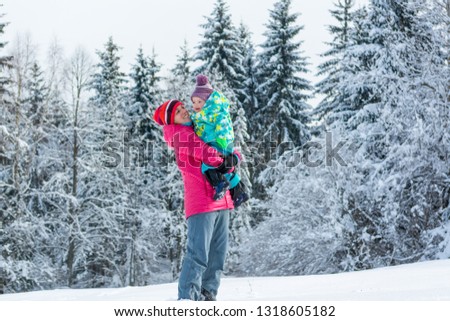 Mother and daughter playing in fairytale winter landscape.