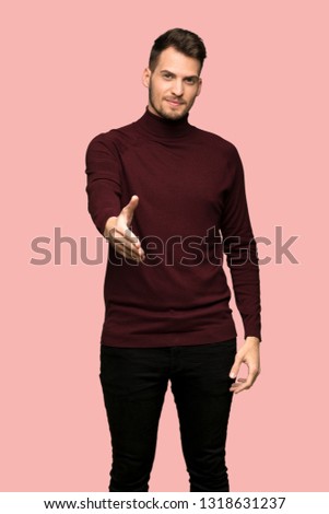 Man with turtleneck sweater shaking hands for closing a good deal over pink background