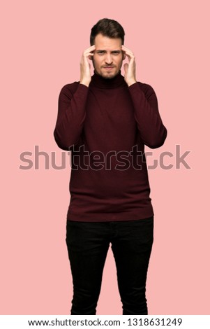 Man with turtleneck sweater with headache over pink background