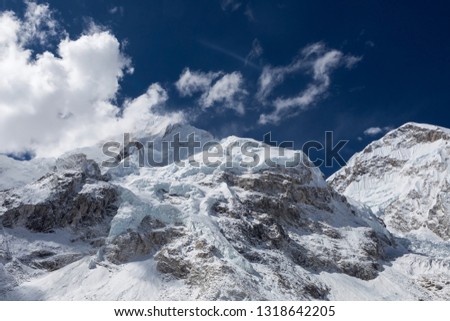 Beautiful snow and ice covered mountains view up to the peaks and blue sky with white clouds from Everest Base Camp, Himalayas, Nepal. Likable photo.