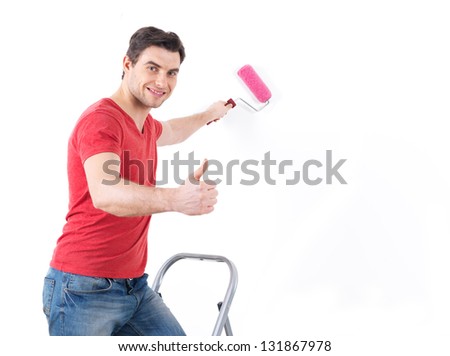 Smiling  worker  painter with brush  showing thumbs up sign isolated on  white background