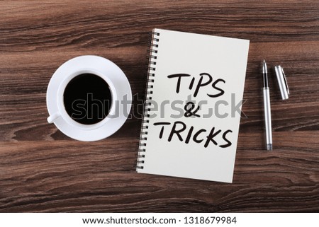 Tips And Tricks concept on desktop workspace with office supplies.