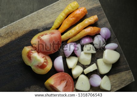 sliced garlic, garlic clove, garlic bulb, tomato, orange Chili, red union in wooden board vintage wooden background - Image