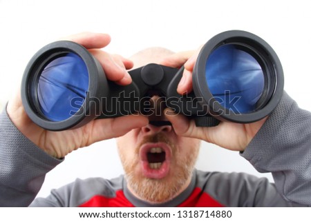 Bearded man looking through binoculars on white background