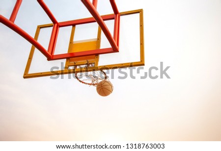 basketball play from bottom view with competition concept to catch ball on blue sky. outdoor sport on day light
