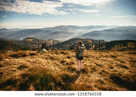 Young woman taking picture of a foggy valley