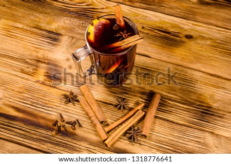 Cup of mulled wine with cinnamon on rustic wooden table
