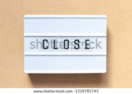 White lightbox with word close on wood background