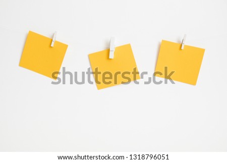 Yellow stickers on clothespins on white background. Copyspace for text