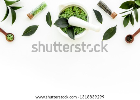 Make cosmetics with tea tree essential oil. Fresh tea tree leaves, mortar and pestel, cosmetics on white background top view border copy space Royalty-Free Stock Photo #1318839299