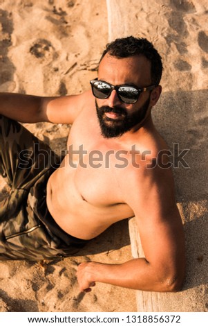 Indian fitness model at beach or bearded young man with muscular physic at sea shore