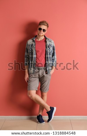 Fashionable young man near color wall